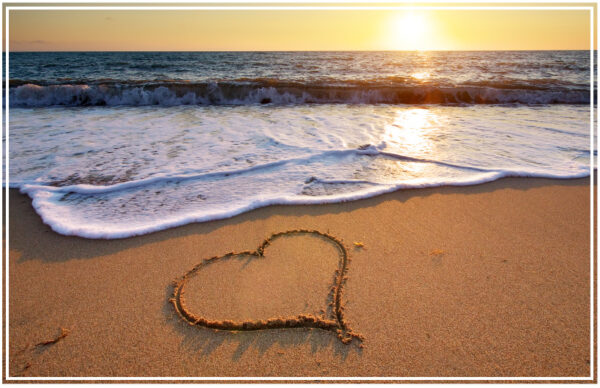 a heart drawn in sand on a beach